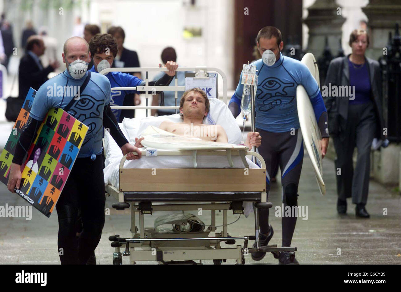 Una delegazione di utilizzatori di acqua potabile guidata da attivisti per l'acqua pulita 'Surfers Against Sewage' con James Hendy che finge di essere un surfer malato in un letto d'ospedale. Andarono in piazza del Parlamento per consegnare una cartolina gigante alla casa dei comuni e per fare lobby a Elliot Morley M.P. Foto Stock