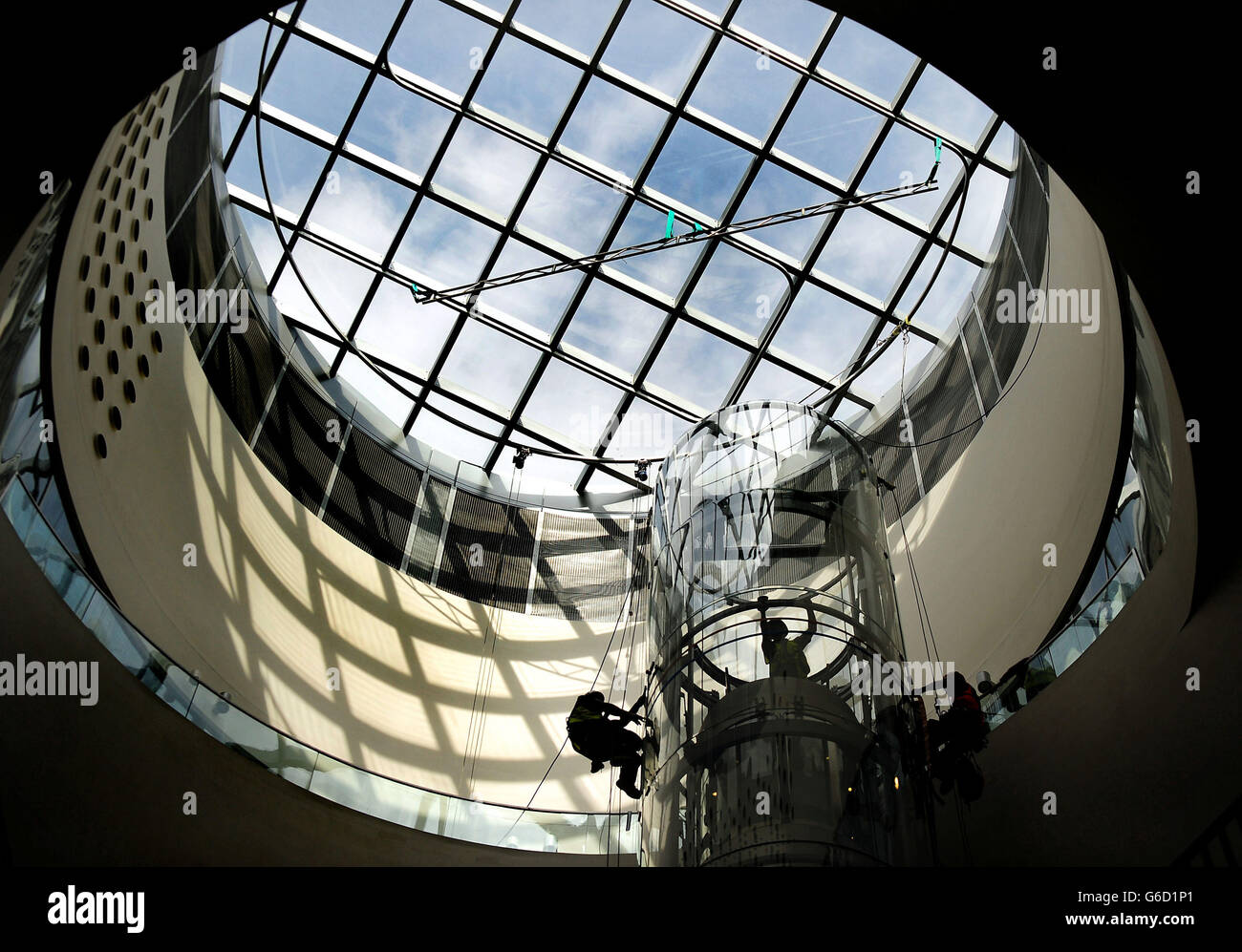 I lavoratori lavorano su un albero di sollevamento trasparente vicino alla cupola della Biblioteca di Birmingham in preparazione della sua apertura ufficiale il 3 settembre, Birmingham progettato dallo studio di architettura Mecanoo. Foto Stock