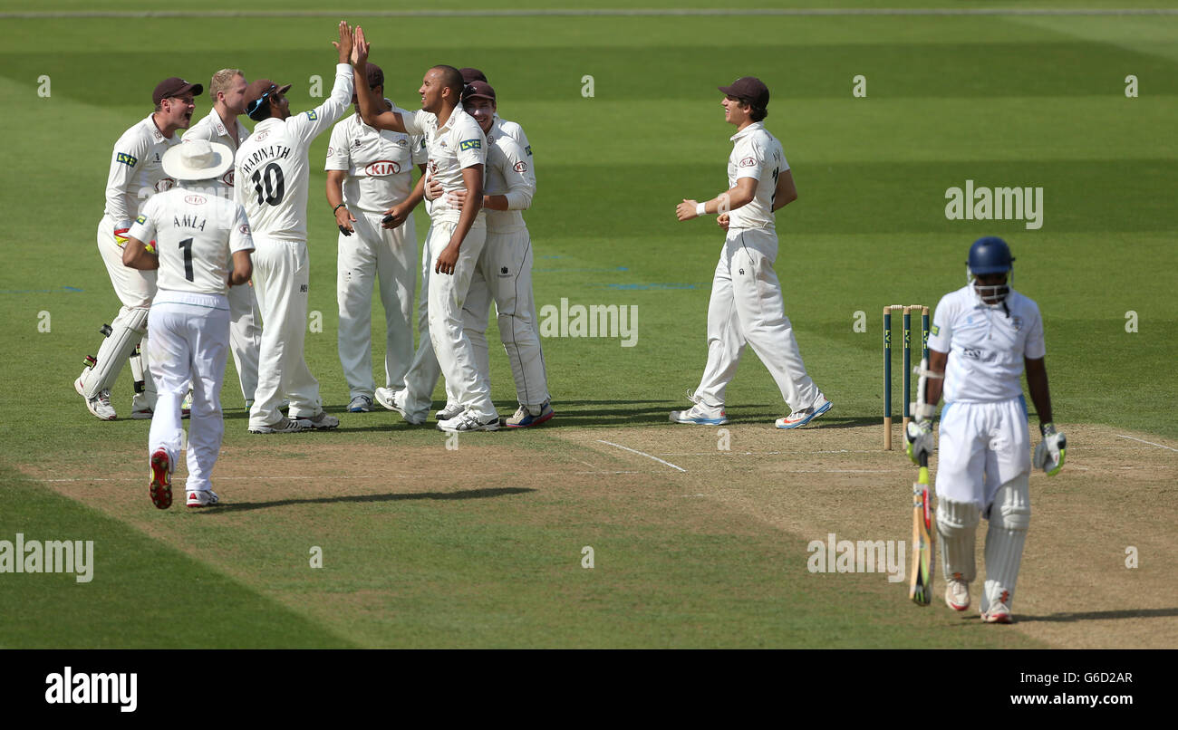 George Edwards del Surrey festeggia con i compagni di squadra dopo aver rimosso l'LBW di Shivnarine Chanderpaul (a destra) del Derbyshire per 46 Foto Stock