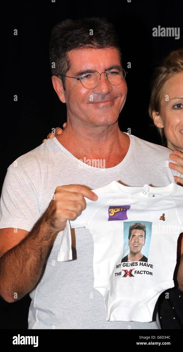Simon Cowell tiene un babygrow in una foto-call al RADA di Londra per lanciare l'X Factor Musical 'i Cant sing'. Foto Stock