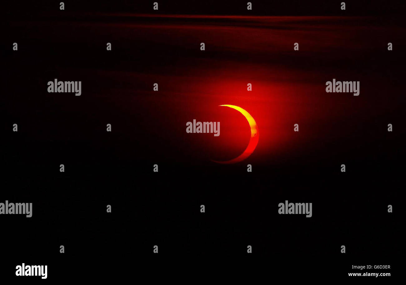 La copertura nuvolosa si muove per un attimo per mostrare la luna che passa davanti al sole alla fine della sua fase sulle cime della scogliera vicino Durness a Sutherland, nel nord della Scozia. *... Un'eclissi anulare è simile a un'eclissi totale, ma il diametro apparente della luna non è abbastanza grande da coprire il disco del sole, lasciando un anello sottile di luce solare visibile. Il motivo è che l'orbita della luna è ellittica. Se si verifica un'eclissi quando la luna è vicina al suo punto più lontano dalla Terra (apogee) allora non copre completamente il sole. Foto Stock