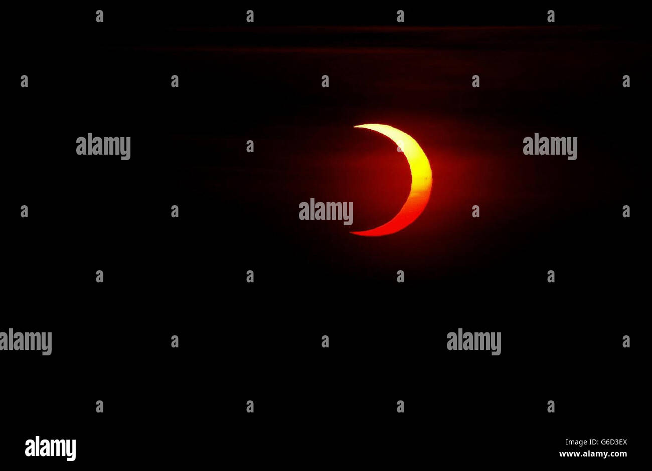 La copertura nuvolosa si muove per un attimo per mostrare la luna che passa davanti al sole alla fine della sua fase sulle cime della scogliera vicino Durness a Sutherland, nel nord della Scozia. *... Un'eclissi anulare è simile a un'eclissi totale, ma il diametro apparente della luna non è abbastanza grande da coprire il disco del sole, lasciando un anello sottile di luce solare visibile. Il motivo è che l'orbita della luna è ellittica. Se si verifica un'eclissi quando la luna è vicina al suo punto più lontano dalla Terra (apogee) allora non copre completamente il sole. Foto Stock