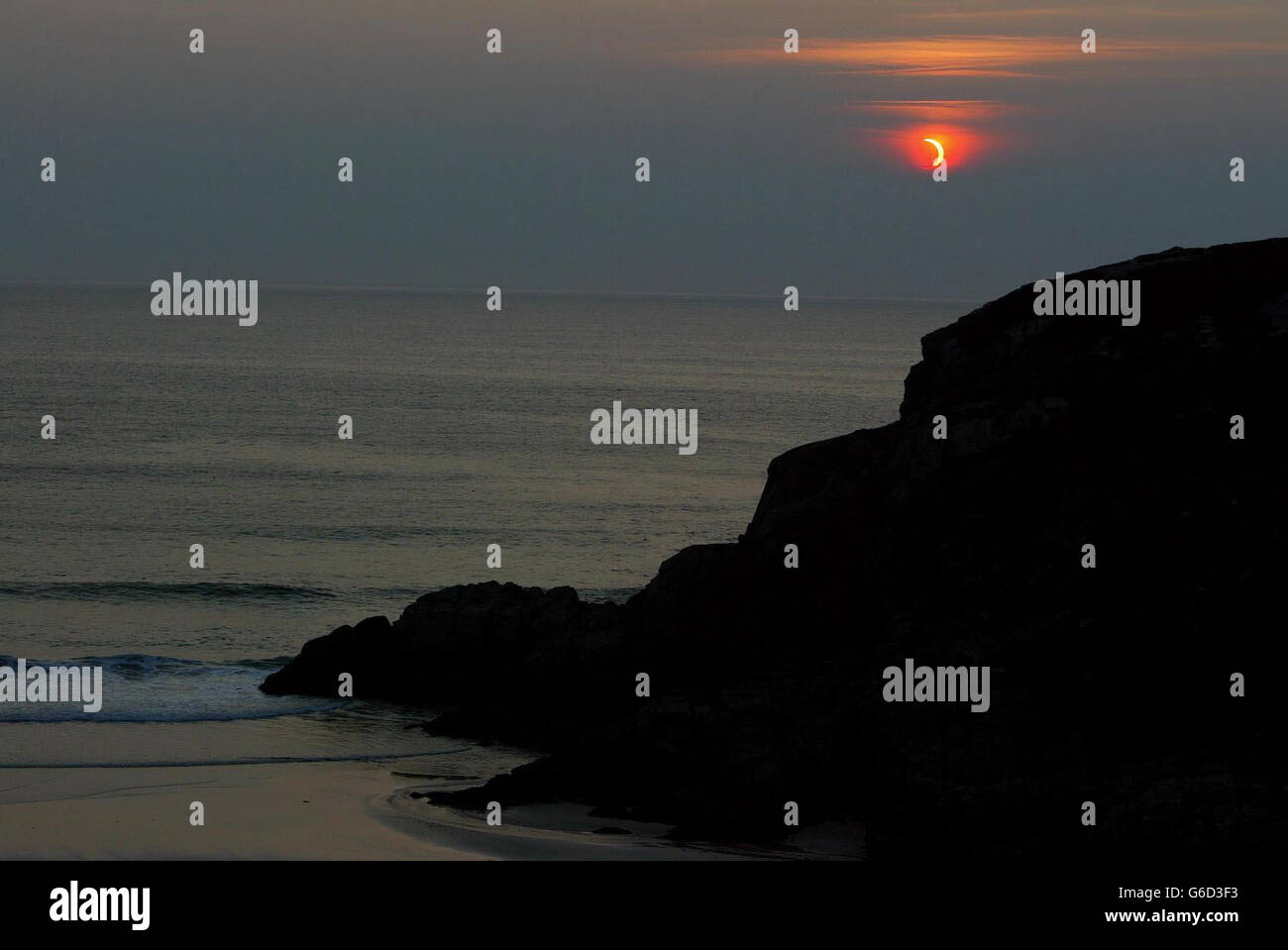 La copertura nuvolosa si muove per un attimo per mostrare la luna che passa davanti al sole alla fine della sua fase sulle cime della scogliera vicino Durness a Sutherland, nel nord della Scozia. *... Un'eclissi anulare è simile a un'eclissi totale, ma il diametro apparente della luna non è abbastanza grande da coprire il disco del sole, lasciando un anello sottile di luce solare visibile. Il motivo è che l'orbita della luna è ellittica. Se si verifica un'eclissi quando la luna è vicina al suo punto più lontano dalla Terra (apogee) allora non copre completamente il sole. Foto Stock