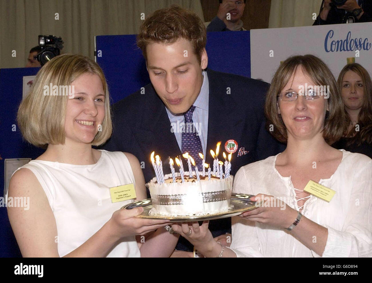 Il principe William soffia le candele sulla sua torta di compleanno durante una visita, alla fiera alimentare di Anglesey nel Galles del nord. Il principe, 21 il sabato seguente, e suo padre sono in Galles per il giorno. ..... (A sinistra) Erin Fon-Jones (17), da Anglesey. Foto Stock