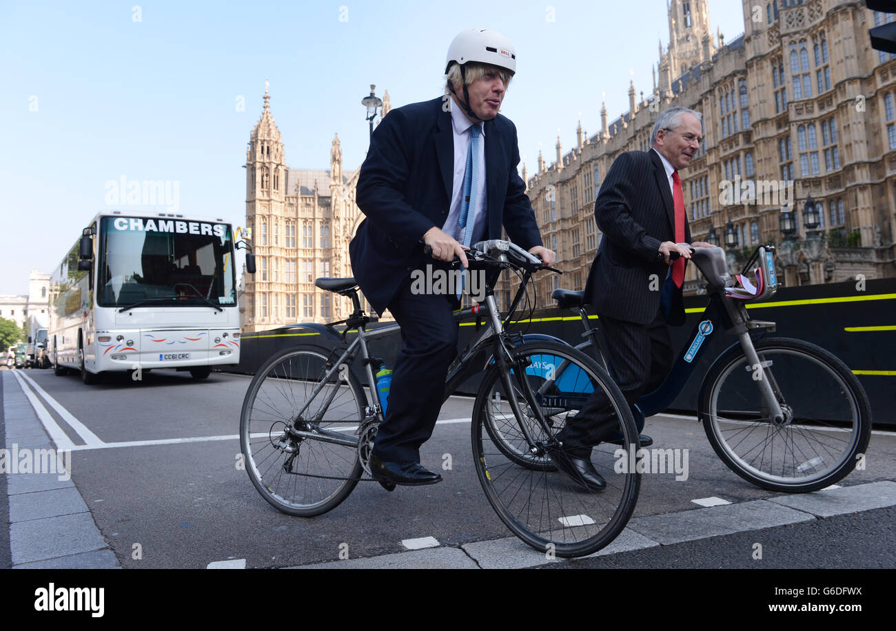 Il sindaco di Londra Boris Johnson e il commissario per i trasporti di Londra Peter Hendy si siedono sulle biciclette di fronte al traffico a Westminster, Londra, mentre incontrano gli agenti di polizia che dimostrano le questioni relative ai conducenti e ai ciclisti HGV in un'iniziativa volta a prevenire ulteriori collisioni con i ciclisti. Foto Stock