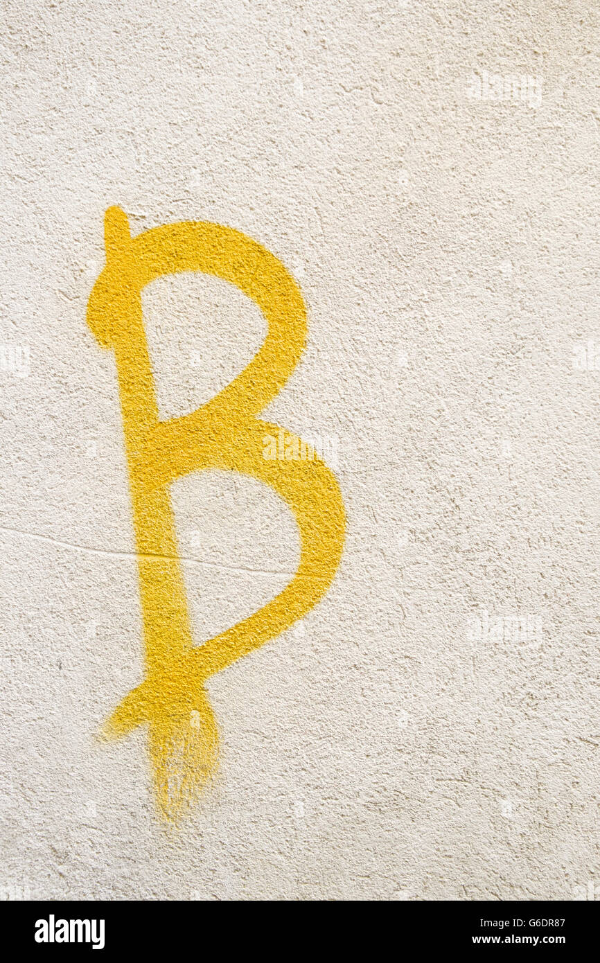 Graffiti di un giallo lettera b spruzzato su una parete in Arezzo, Italia. Foto Stock