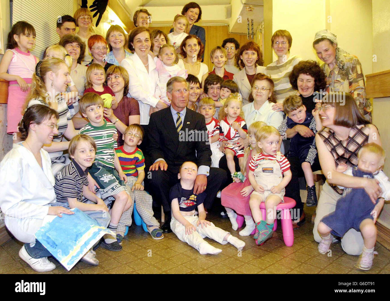 Il Principe del Galles pone con i bambini durante la sua visita il 'Early Intervention Institute' per le famiglie di bambini con bisogni speciali, a San Pietroburgo, nella Russia settentrionale, come parte del suo tour di tre giorni della Russia. Foto Stock