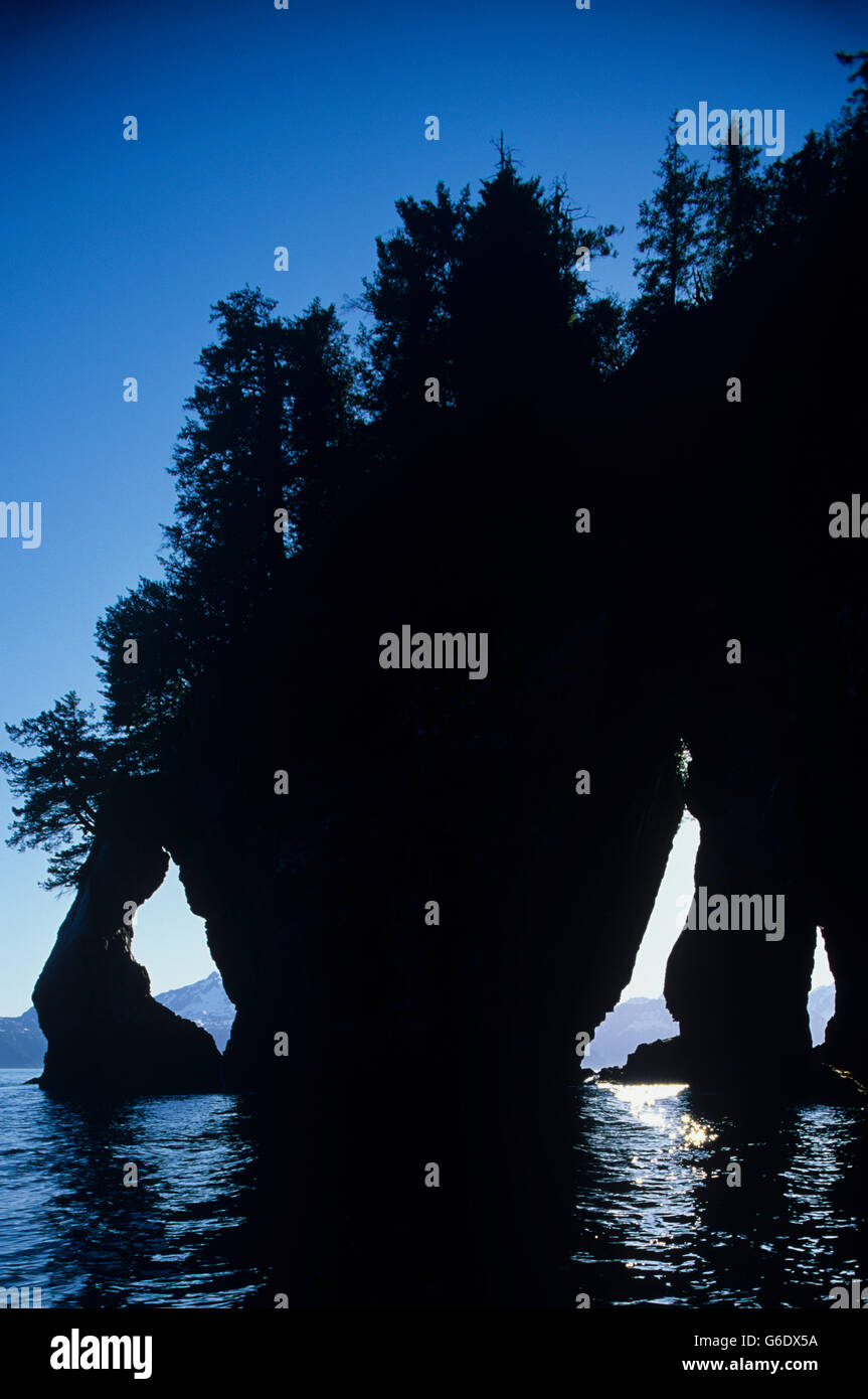 Stati Uniti d'America, Alaska, il Parco nazionale di Kenai Fjords, tre foro Rock e impostazione di sole estivo lungo la baia di Aialik Foto Stock