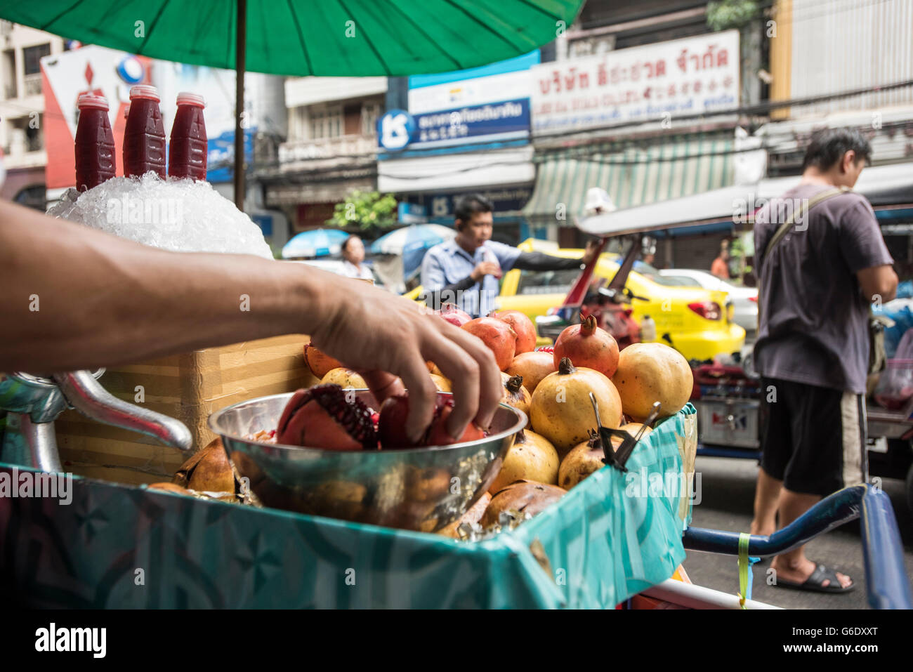 La gente a piedi passato un cibo di vendita Carrello melagrane nel quartiere di Chinatown di Bangkok, Thailandia, il 25 aprile 2015. Foto Stock