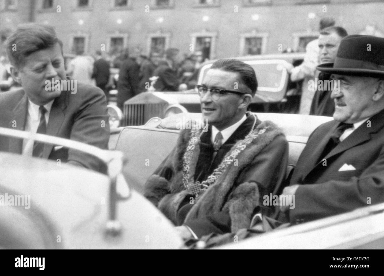 IL PRESIDENTE JOHN F. KENNEDY d'America, accompagnato in auto da ALDERMAN SEAN CASEY, sindaco di Cork, e FRANK ai KEN, ministro degli Affari esteri dell'Eire, guida da Collins Barracks al municipio di Cork dopo il suo arrivo in elicottero durante la sua visita di tre giorni in Irlanda. Il sig. Kennedy riceverà la libertà della città presso il municipio. Foto Stock