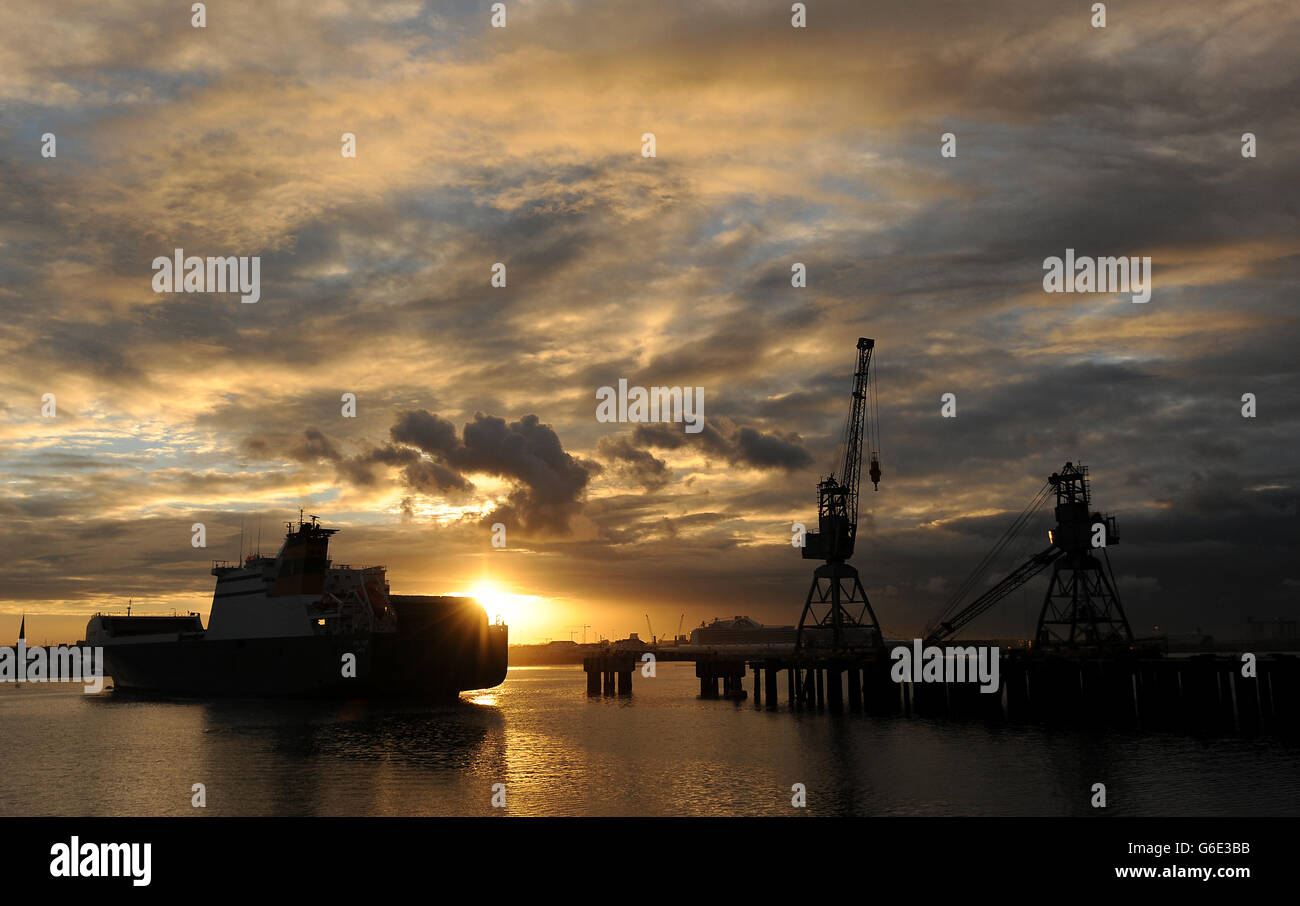 Il Sole sorge sul Solent quando Anvil Point, un tre ponti rotolanti su un traghetto, arriva al Marchwood Sea Mounting Center di Southampton per scaricare i veicoli militari di ritorno dall'Afghanistan. Foto Stock