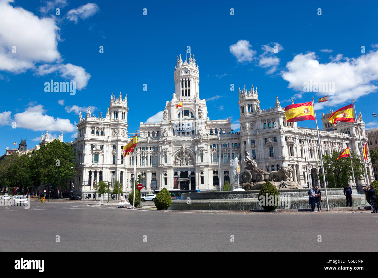 Cibele Palace (Municipio) con "profughi" Benvenuto banner appesi e fontana in Plaza de Cibeles, Madrid, Spagna Foto Stock