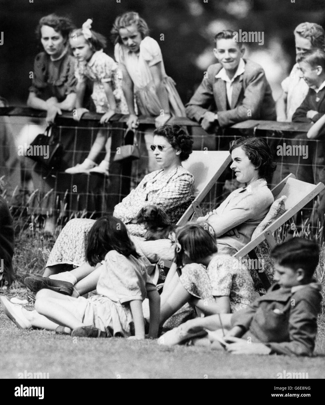 Gli spettatori interessati nelle sedie a sdraio presso il campo da cricket del villaggio di Mersham-le-Hatch, vicino ad Ashford, Kent, sono la principessa Elizabeth (a sinistra) e Lady Brabourne. Stanno guardando i loro mariti giocare per la squadra di Mersham in una partita contro il vicino villaggio di Aldington. Il duca di Edimburgo aveva un breve inning - era fuori gamba prima di wicket fuori dalla prima palla che ricevesse, ma quando il bowling stesso prese due wickets. Lord Brabourne era il custode del cricket di Mersham. La Principessa e il Duca stanno trascorrendo il week-end come ospiti di Lord e Lady Brabourns a Mersham. Foto Stock