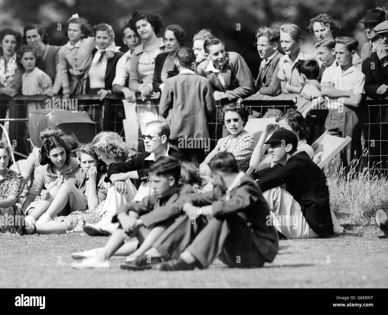 Gli spettatori interessati nelle sedie a sdraio presso il campo da cricket del villaggio di Mersham-le-Hatch, vicino ad Ashford, Kent, sono la principessa Elizabeth (a sinistra) e Lady Brabourne. Stanno guardando i loro mariti giocare per la squadra di Mersham in una partita contro il vicino villaggio di Aldington. Il duca di Edimburgo aveva un breve inning - era fuori gamba prima di wicket fuori dalla prima palla che ricevesse, ma quando il bowling stesso prese due wickets. Lord Brabourne era il custode del cricket di Mersham. La Principessa e il Duca stanno trascorrendo il week-end come ospiti di Lord e Lady Brabourns a Mersham. Foto Stock