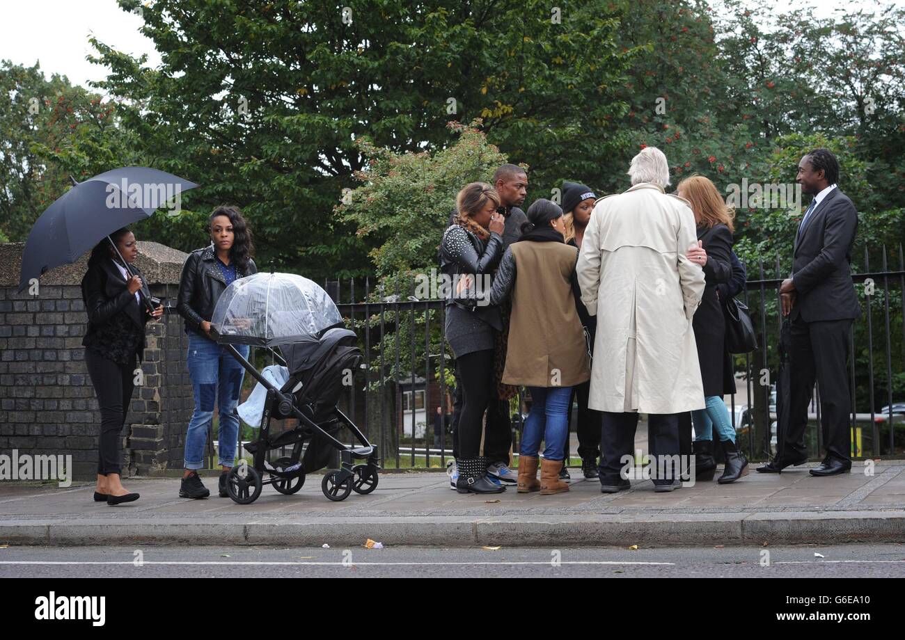 La famiglia e gli amici di Mark Duggan, accompagnati da Michael Mansfield QC (cappotto leggero) guardano come la giuria nella conquista della sua morte visitare la scena del suo tiro a Tottenham, a nord di Londra. Foto Stock