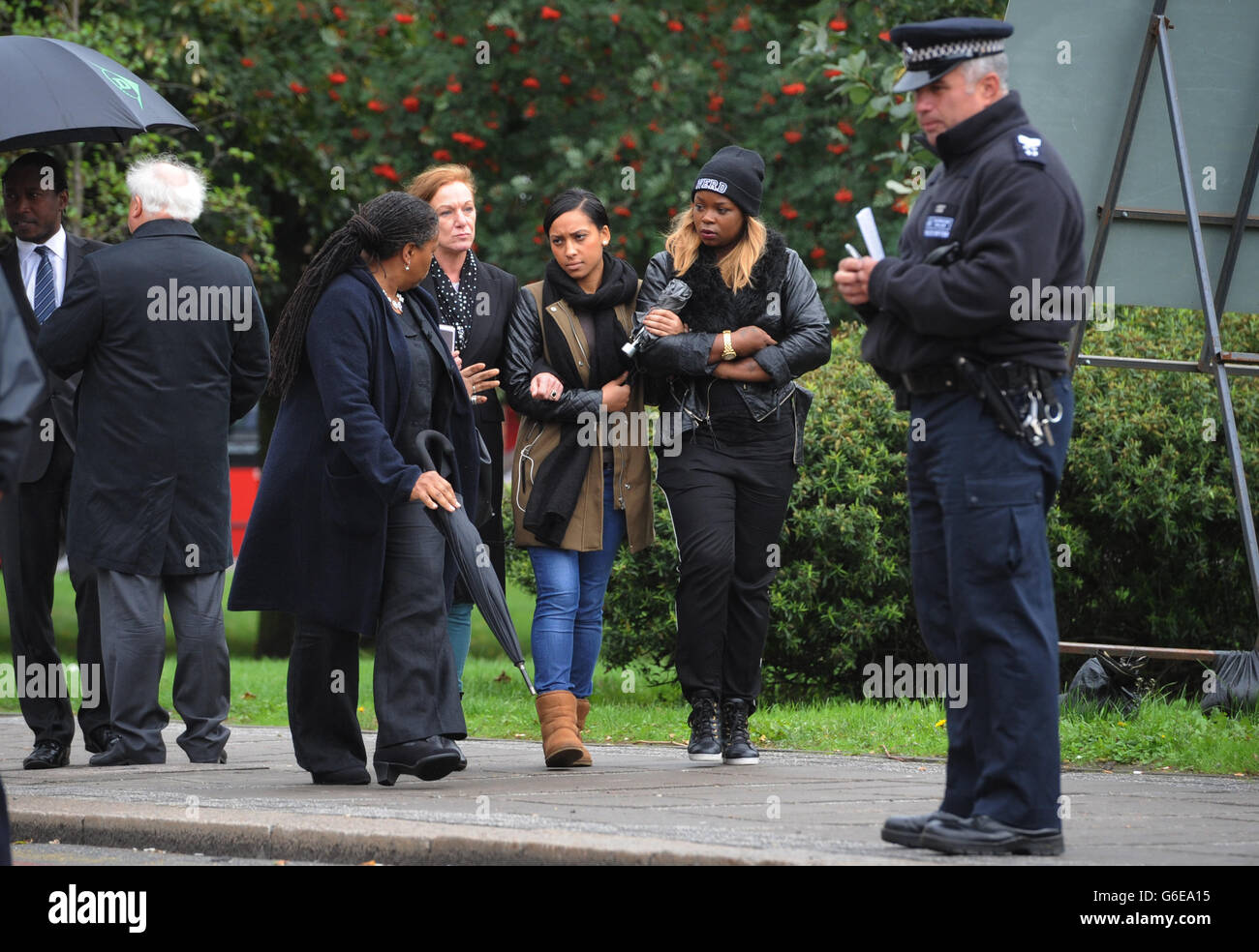 La famiglia e gli amici di Mark Duggan guardano su come la giuria nella conquista della sua morte visita la scena della sua sparatoria a Tottenham, a nord di Londra. Foto Stock