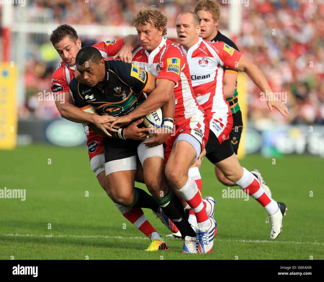 Henry Trinder di Gloucester Rugby (a sinistra) e Billy Twelvetrees affrontano Luther Burrell dei Northampton Saints durante la partita di Aviva Premiership al Kingsholm Stadium di Gloucester. Foto Stock