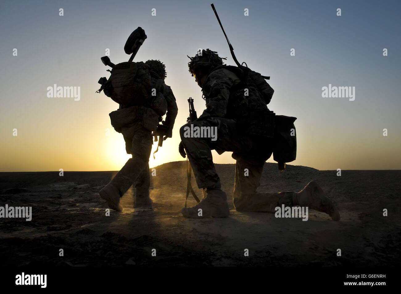 Il sole sorge quando i soldati del 1° Battaglione reggimento reale Fusiliers si spostano da una posizione ferma mentre conducono una pattuglia del piede all'alba nel distretto di Nahr-e Saraj, nella provincia di Helmand, in Afghanistan dopo aver lasciato la base Sterga 2. Foto Stock