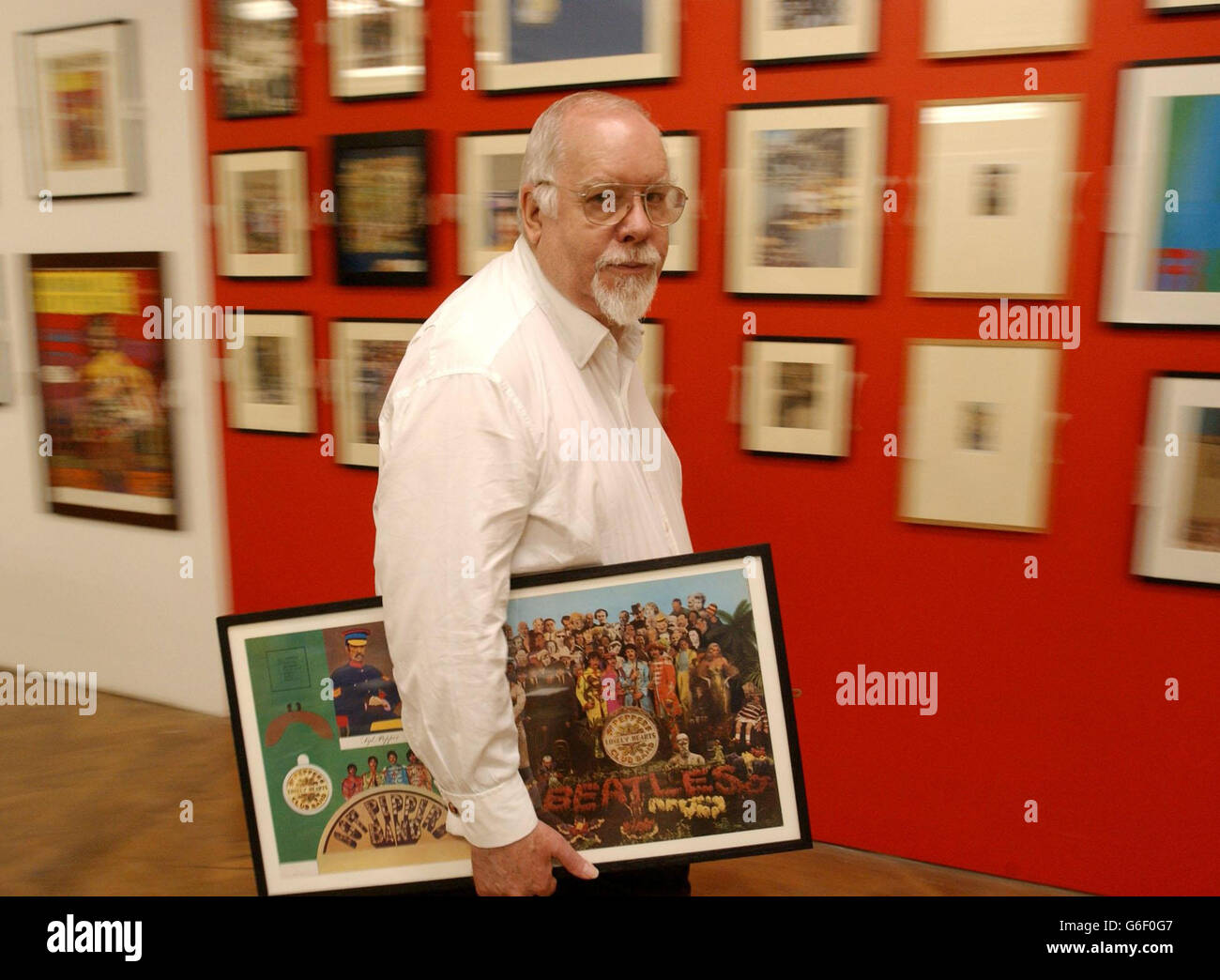 L'artista pop Sir Peter Blake porta il suo pezzo commerciale più famoso - la copertina dell'album per la Sgt Peppers Lonely Hearts Club Band dei Beatles - mentre aiuta a appendere il suo nuovo esposizio alla London Institute Gallery di Mayfair. La mostra, intitolata Peter Blake RA - Commercial Art 1960 - 2003 apre al pubblico dal 4 agosto al 11 settembre. Foto Stock