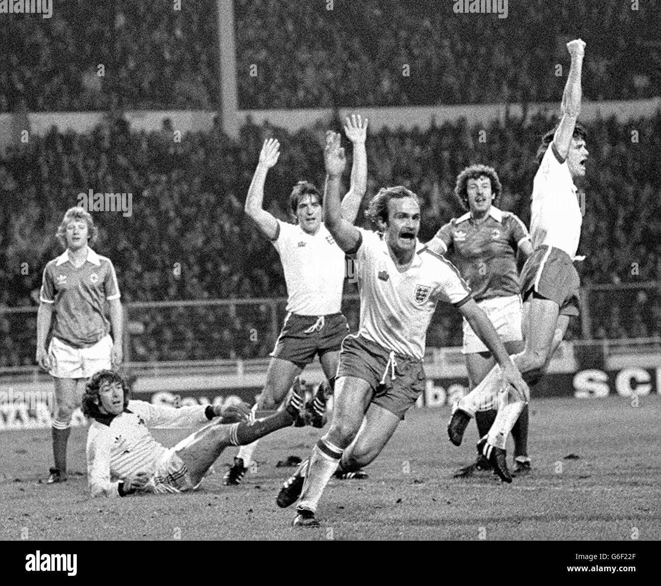 Giubilo dei giocatori inglesi Bob Latchford, Mick Mills (centro) e Dave Watson dopo che Watson aveva guidato a casa il terzo gol dell'Inghilterra dopo 50 minuti di gioco in una partita di qualificazione del Campionato europeo contro l'Irlanda del Nord a Wembley. Il guardiano dell'Irlanda del Nord Pat Jennings si trova senza aiuto di Jimmy Nicholl e Gerry Armstrong (a destra). Foto Stock