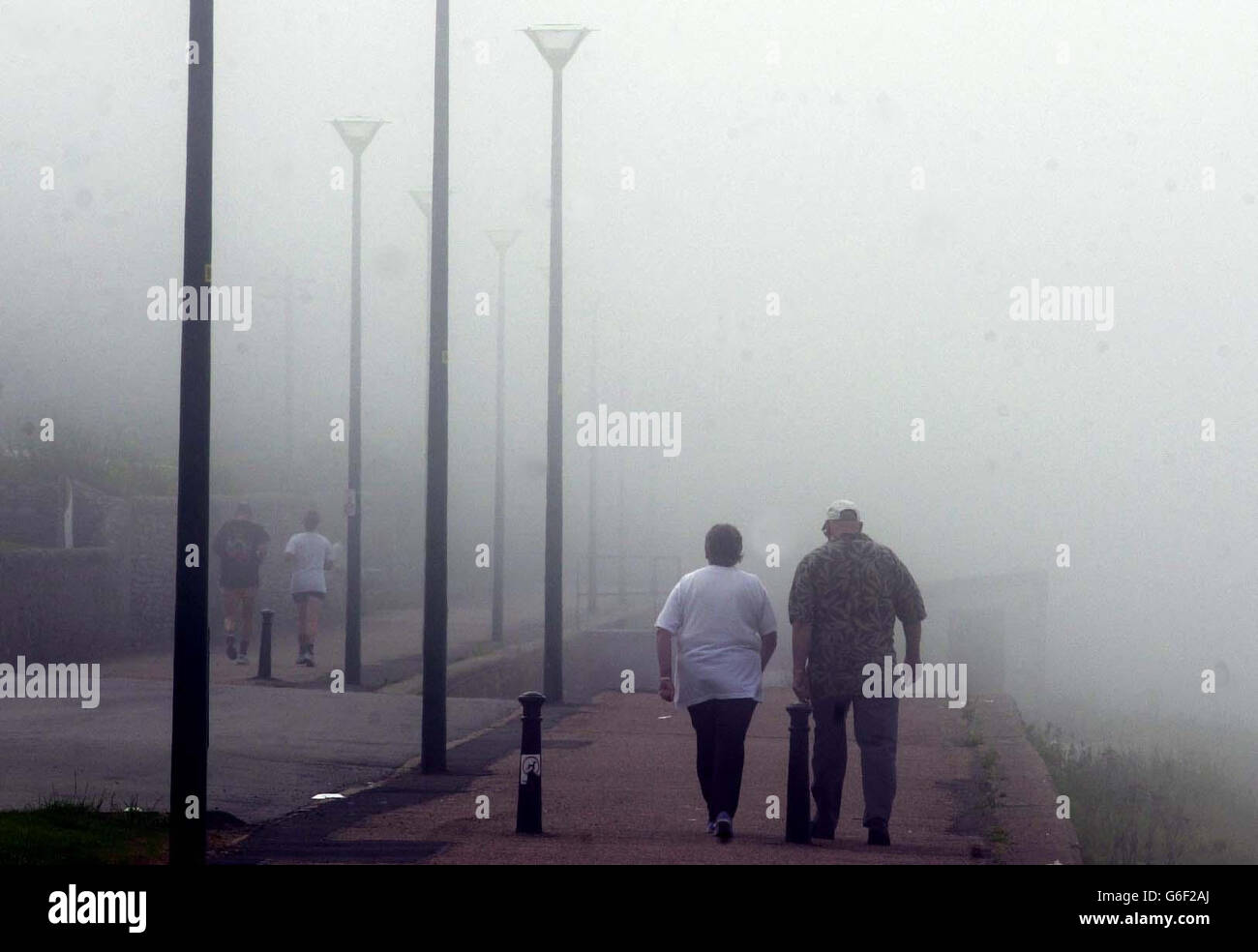 La gente cammina lungo la spiaggia di Thurso in una fitta nebbia mentre altre parti del paese crogiolano al sole. Foto Stock