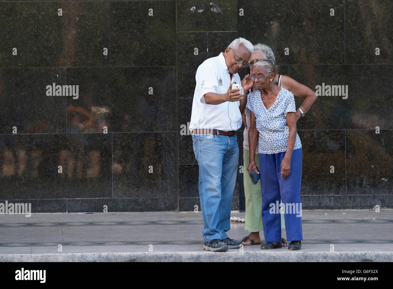 Le persone anziane a Cuba utilizzando un telefono cellulare Foto Stock