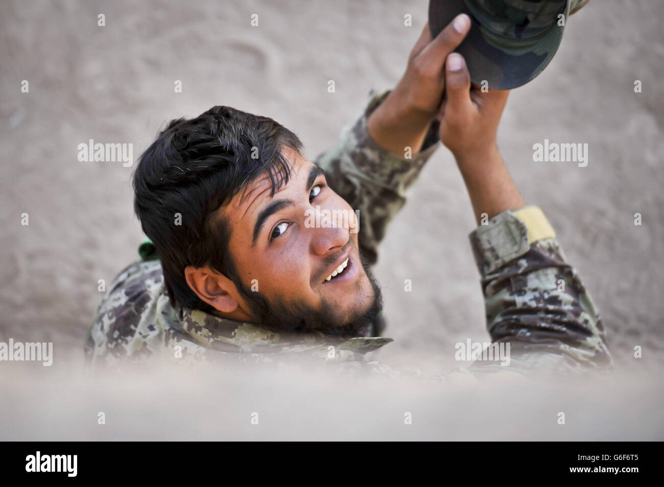 Un soldato dell'esercito nazionale afgano (ANA) si siede all'ombra durante una pausa tra una sessione di addestramento e l'altra a campo di Shorabak, nella provincia di Helmand, in Afghanistan. Foto Stock