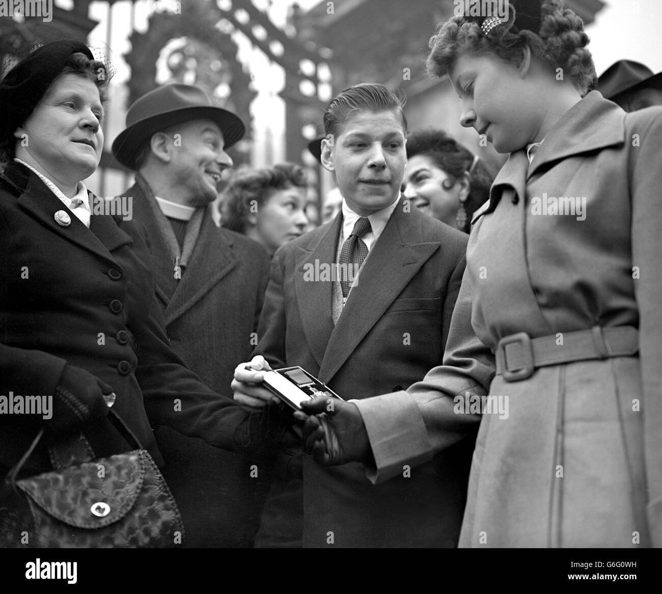 John Bamford, 16 anni, mostra la sua George Cross a sua sorella Jean fuori Buckingham Palace. Gli è stata assegnata la Croce di George per aver salvato i suoi due fratelli da una camera da letto ardente. Foto Stock
