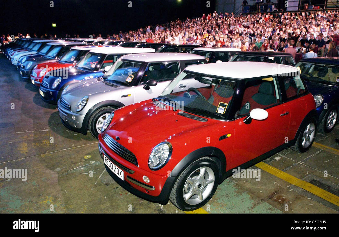 Le mini auto sono allineate di fronte a una folla di dipendenti (background) riuniti per guardare una proiezione speciale del nuovo film "The Italian Job", su uno schermo gigante (non raffigurato) presso la Cowley BMW Mini stabilimento di Oxford. Foto Stock