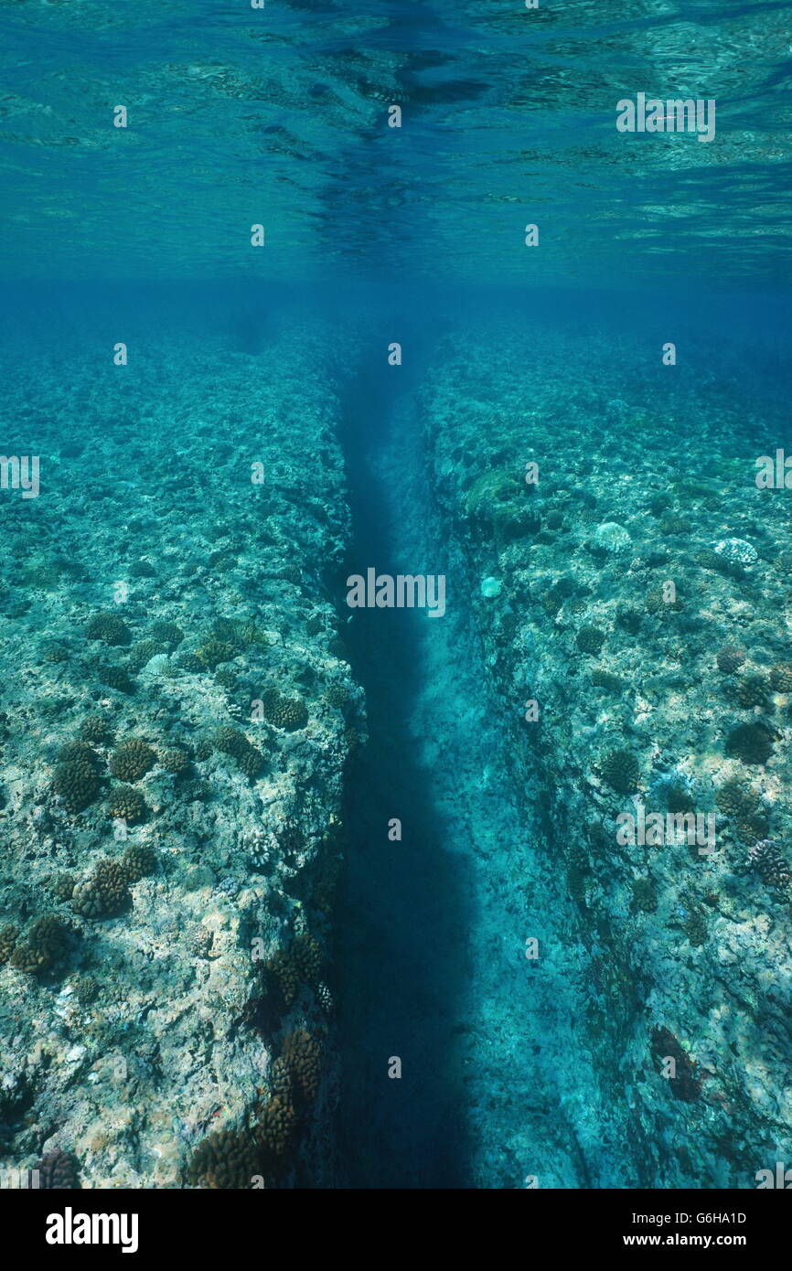 Paesaggio sottomarino, in trincea scavata a onda gonfiarsi nella barriera corallina a Huahine isola, oceano pacifico, Polinesia Francese Foto Stock