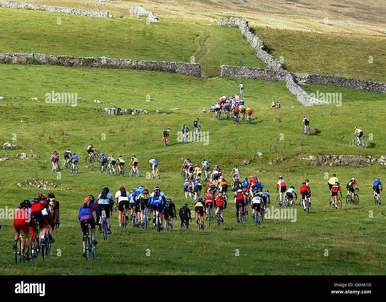 Parti per una sfida impegnativa, con oltre 300 ciclisti che affrontano la salita di Ingleborough nella Three Peaks Cyclo Cross Race. Considerato come l'evento ciclocross più impegnativo al mondo, il pilota si trova sulla vetta dei tre Yorkshire Dales Peaks Ingleborough, Whernside e Pen y Ghent, che coprono 61 chilometri. Foto Stock