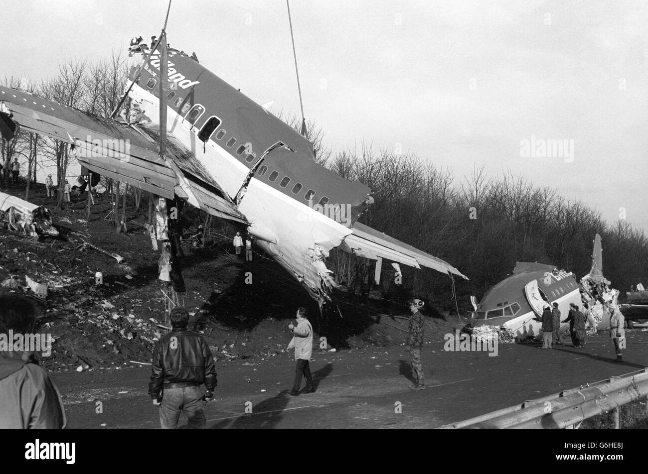 La fusoliera e le ali sminuzzate del British Midland 737 vengono tolte dall'argine M1 vicino a Kegworth, Leicestershire, sotto la supervisione di esperti della filiale di indagine sugli incidenti aerei del Department of Transport. Foto Stock