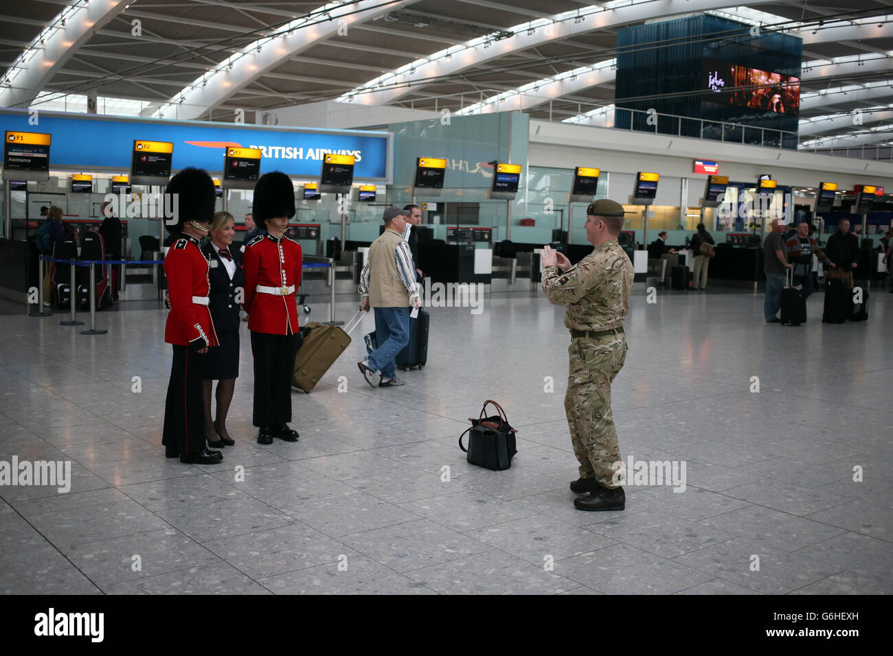Un dipendente di BA con soldati nel terminal 5 dell'aeroporto di Heathrow a Londra che si univano ai venditori di papavero nel London Poppy Day della Royal British Legion (RBL). Foto Stock