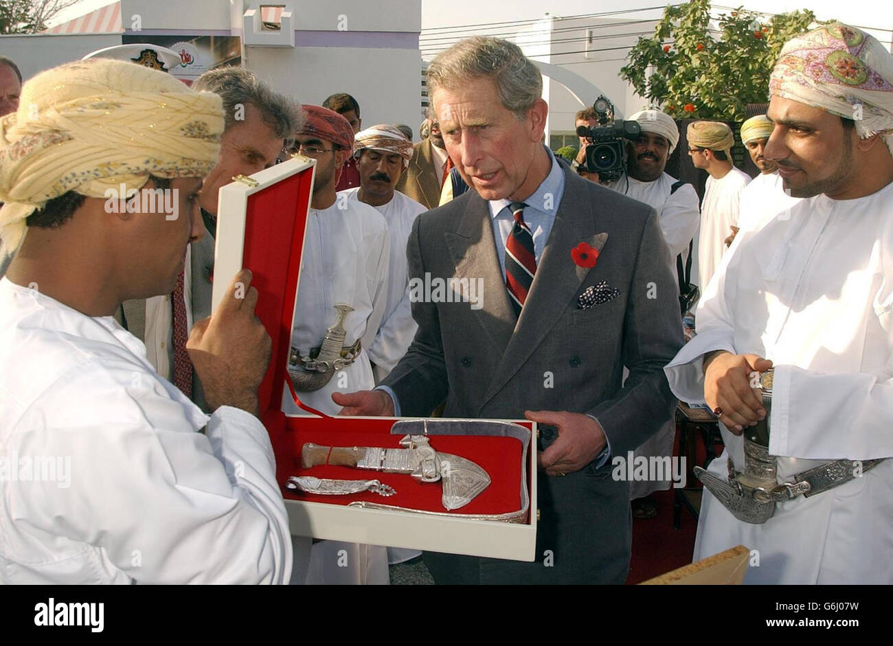 Il Principe di Galles viene presentato con un tradizionale pugnale decorativo, durante una visita alla vetrina delle giovani imprese Omani, a Muscat, la capitale dello stato arabo dell'Oman. Foto Stock
