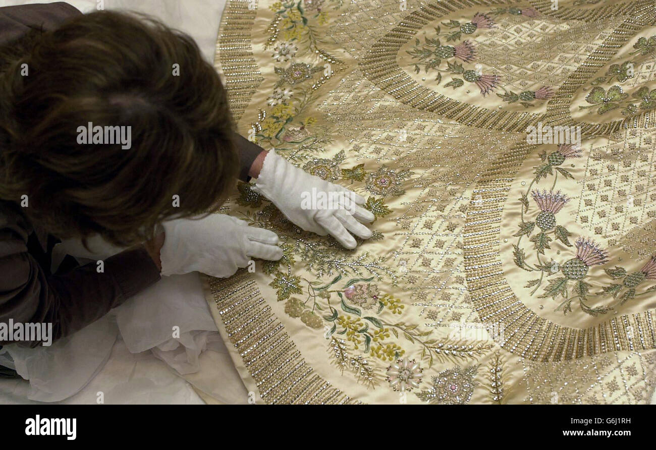 Il vestito e il vestito di incoronazione della regina Elisabetta II della proprietà è controllato sopra da Sally Andrew, il conservatore tessile anziano dei palazzi reali storici a Hampton Court, prima che il vestito e il Robe vadano in esposizione al castello di Windsor in il 8 ottobre fino al 4 gennaio 2004, Lunedì 6 ottobre 2003. A causa del popolare appello di cerimonia e Celebrazione: Giorno dell'incoronazione 1953 all'apertura estiva delle Sate Rooms a Buckingham Palace (aperto fino al 28 settembre 2003) questi accappatoi continueranno ad essere esposti fino alla fine dell'anno dell'incoronazione nella Sala Garter Throne al Castello di Windsor. Foto Stock