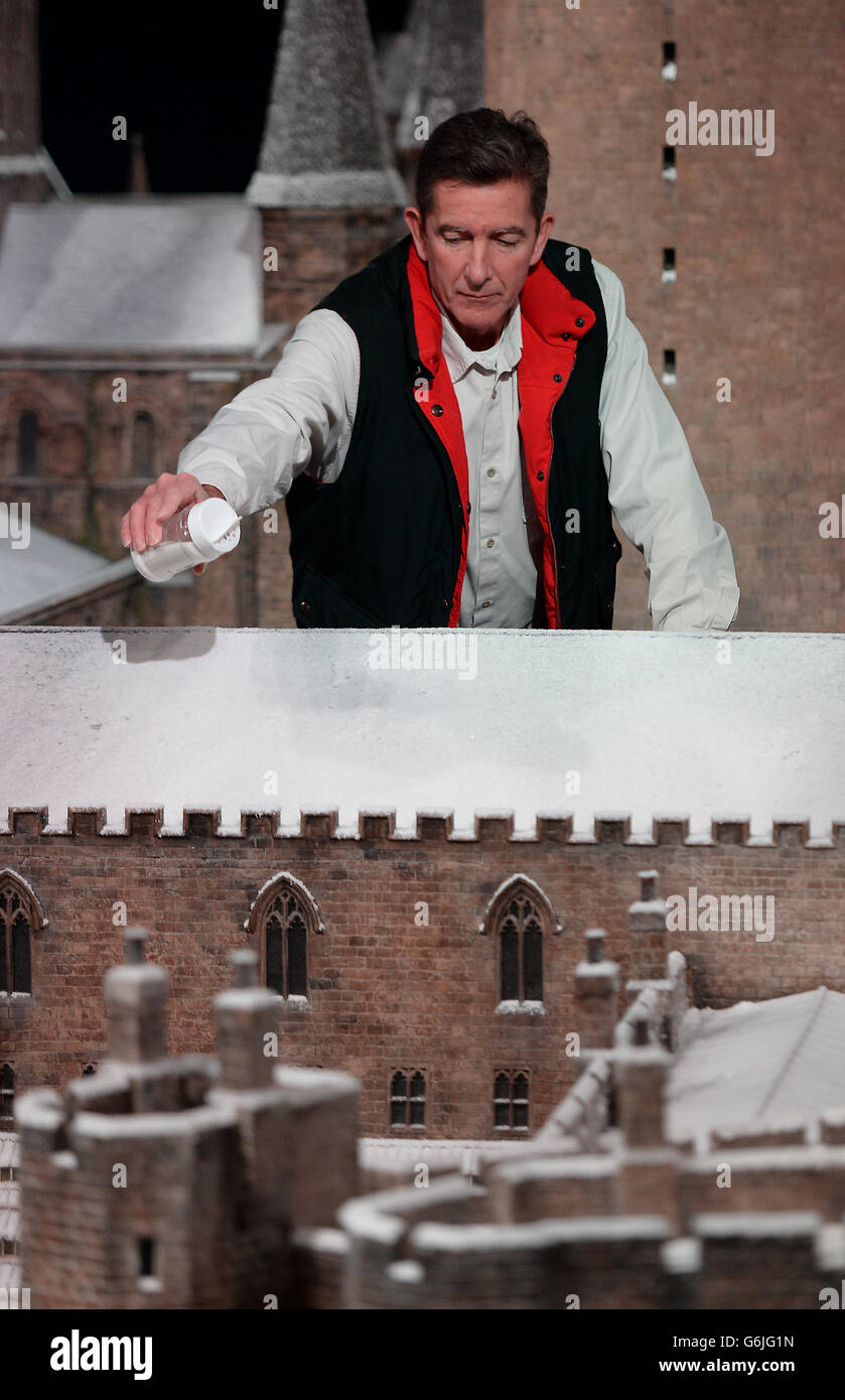 Il supervisore di effetti modello Jose Granell aggiunge alcuni degli ultimi spruzzi di neve al modello della scuola di Hogwarts a Warner Bros. Studio Tour Londra - The Making of Harry Potter, a Watford, North-West London. Foto Stock