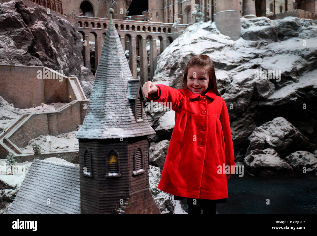 La ragazza della scuola locale Robyn, di 7 anni, (cognome non dato) aggiunge alcuni degli ultimi spruzzi di neve al modello di Hogwarts School a Warner Bros. Studio Tour Londra - The Making of Harry Potter, a Watford, North-West London. Foto Stock
