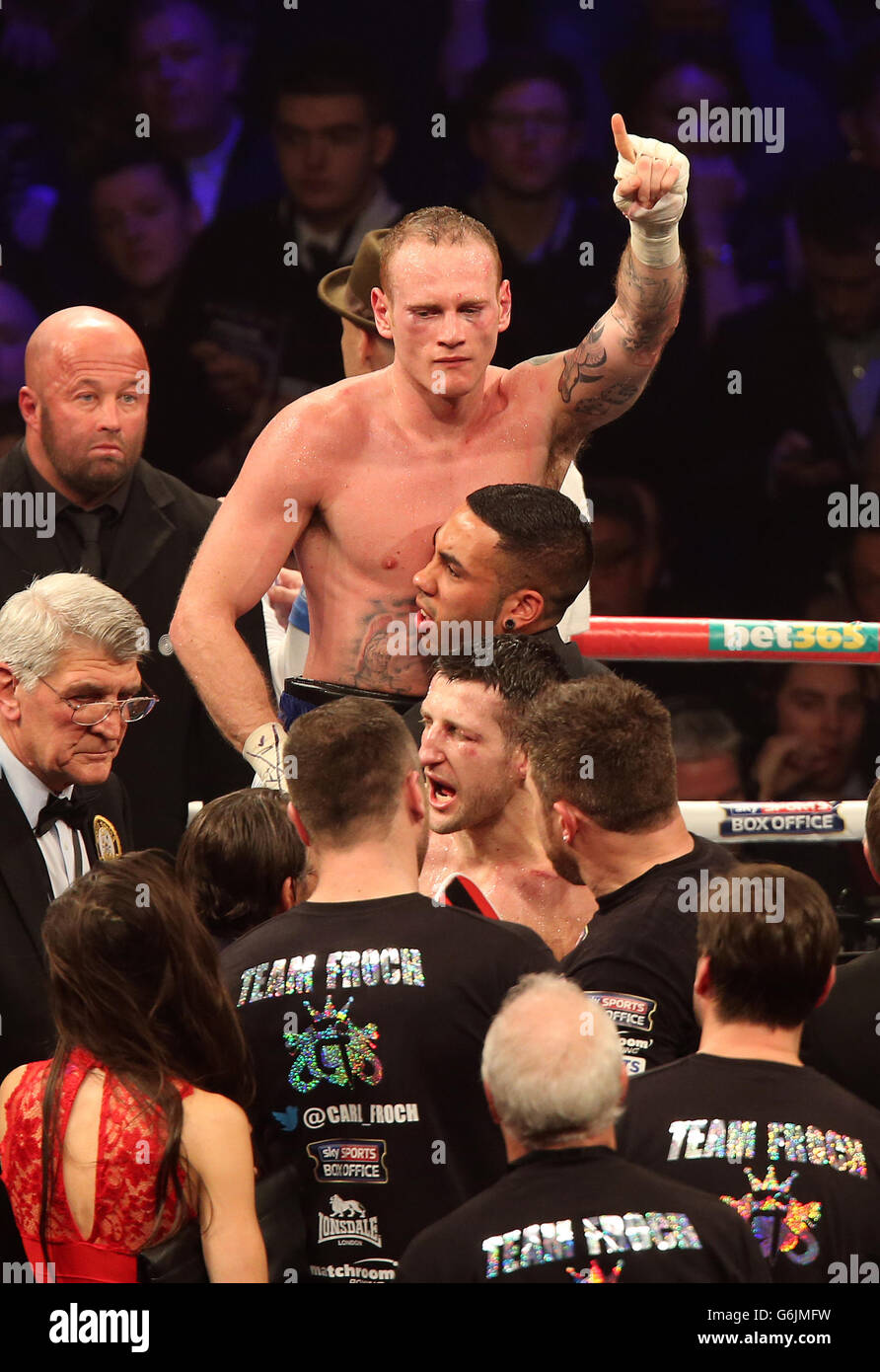 George Groves (in alto al centro) sorge sopra Carl Froch (in basso al centro) e la sua squadra dopo aver perso la WBA e IBF Super Middleweight Title Fight alla Phones 4u Arena, Manchester. Foto Stock