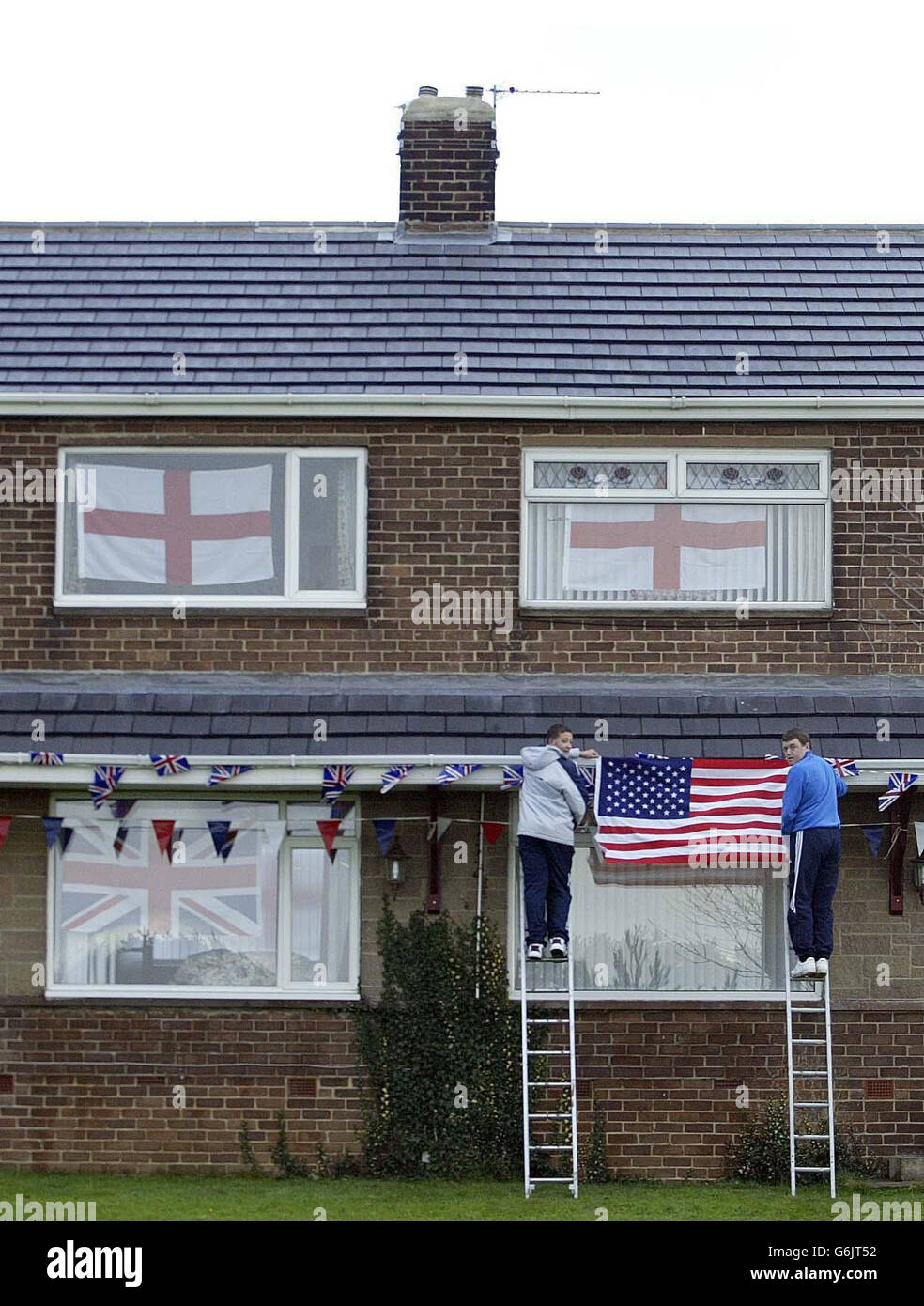 I residenti di Trimdon hanno messo in su bandiere accanto alla casa dell'ex serveman del RAF e vicino del primo ministro Tony Blair, Owen Willoughby, 84 (casa sulla sinistra) che è morto, Il giorno prima è stato invitato a un pranzo da pub storico con il primo Ministro e il Presidente degli Stati Uniti George Bush a Sedgefield, nella contea di Durham. Owen Willoughby visse direttamente di fronte alla casa di Myrobella, la residenza del collegio elettorale di Blair, e domani, durante la sua visita di Stato in Gran Bretagna, avrebbe dovuto pranzare con il Presidente. Foto Stock