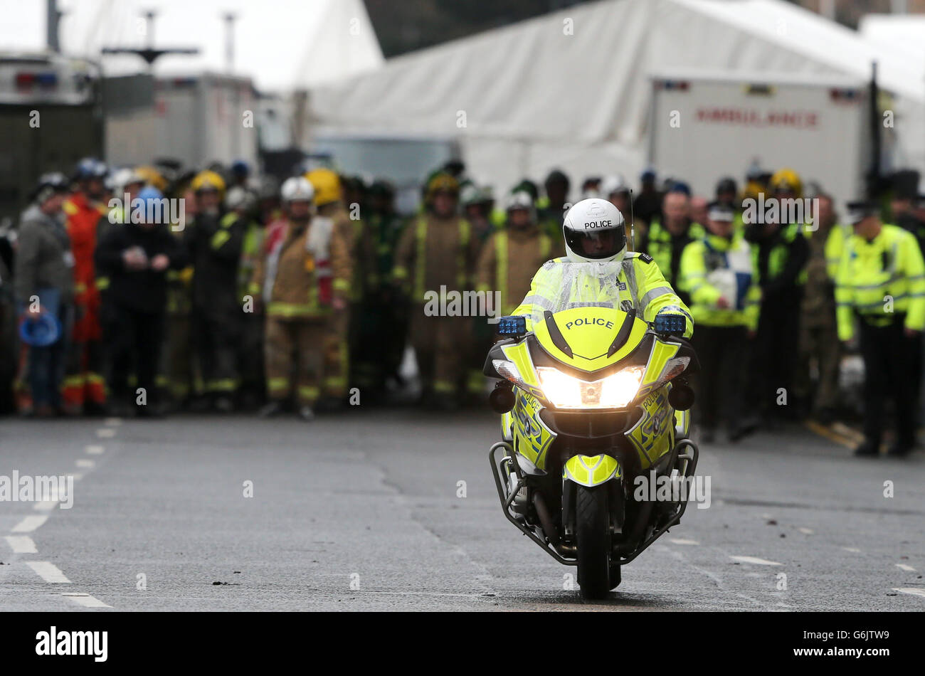 Il personale dei servizi di emergenza fa il loro modo di formare un saluto della Guardia d'onore per una delle vittime è portato da ambulanza privata lontano dal pub Clutha Vaults a Glasgow dopo che un elicottero della polizia si è schiantato in esso il venerdì sera. Foto Stock