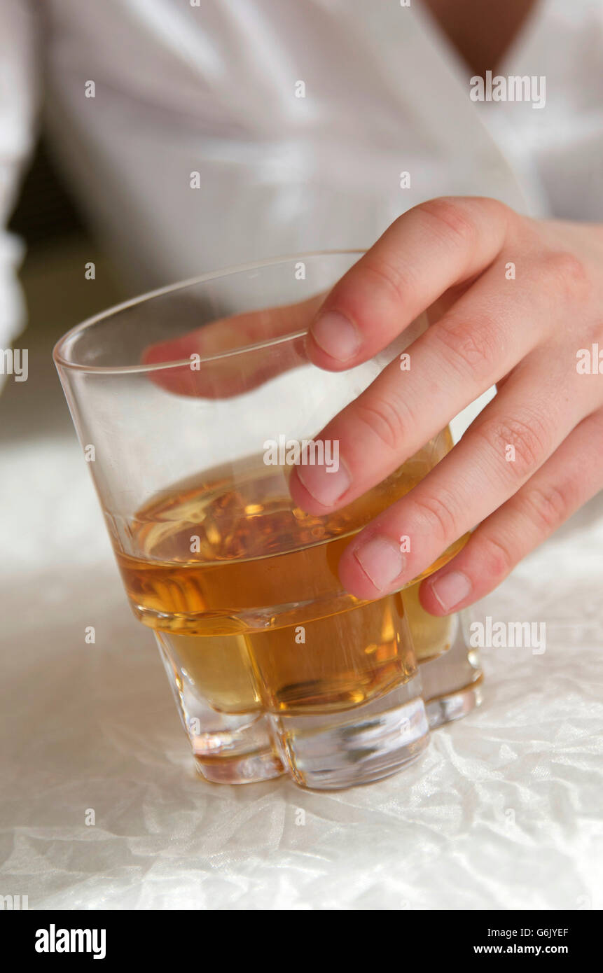 Donna di mano in mano un bicchiere di liquore duro, alcolismo femmina Foto Stock