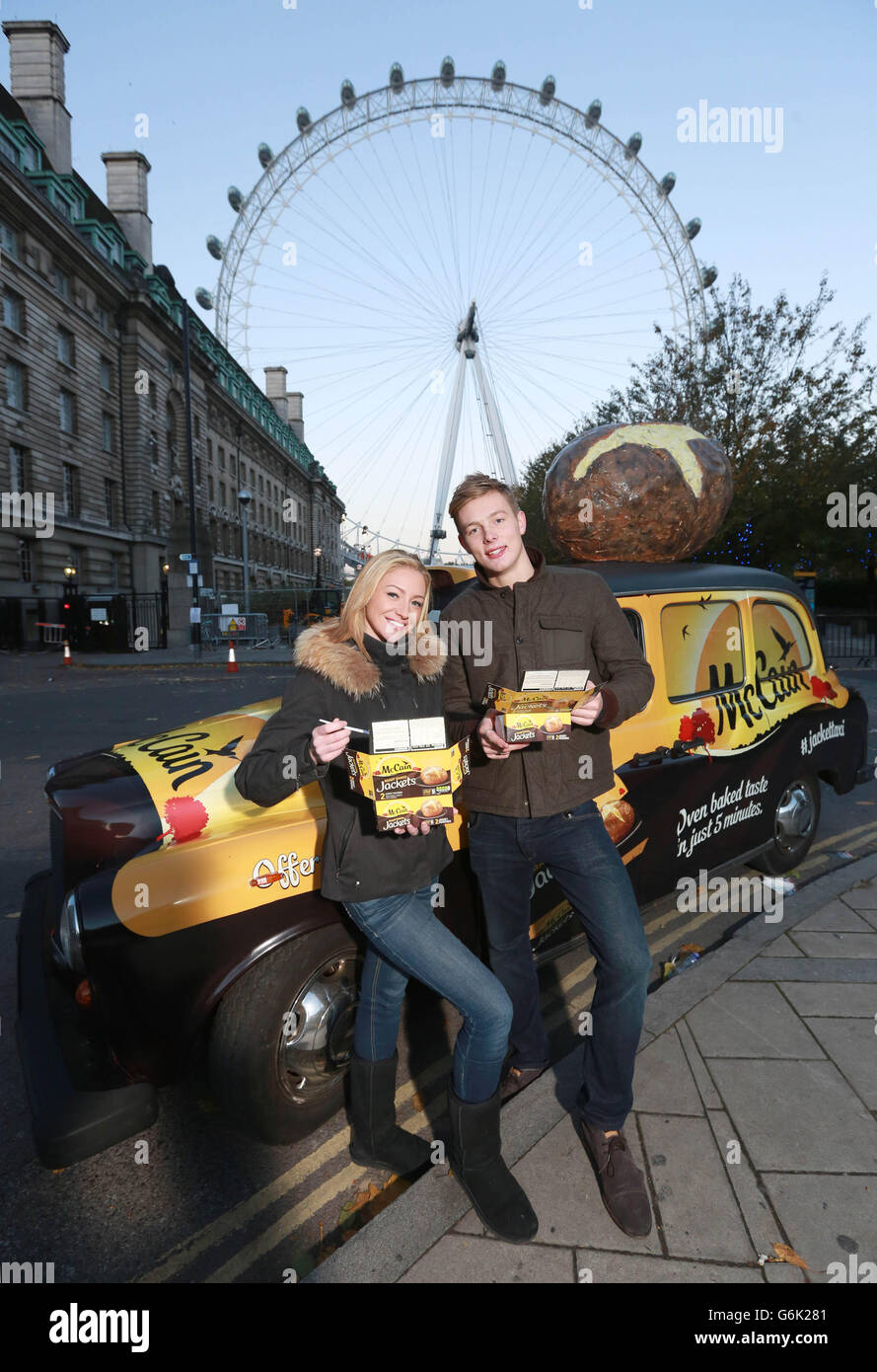 Roisin Acraman da Hertford e Hector Grenville da Finsbury Park, Londra, mangia una patata McCain Ready Baked Jacket cotta nel Jacket Taxi, un taxi appositamente modificato con strutture di cottura delle patate incorporate, parcheggiato di fronte al London Eye di Londra. Foto Stock