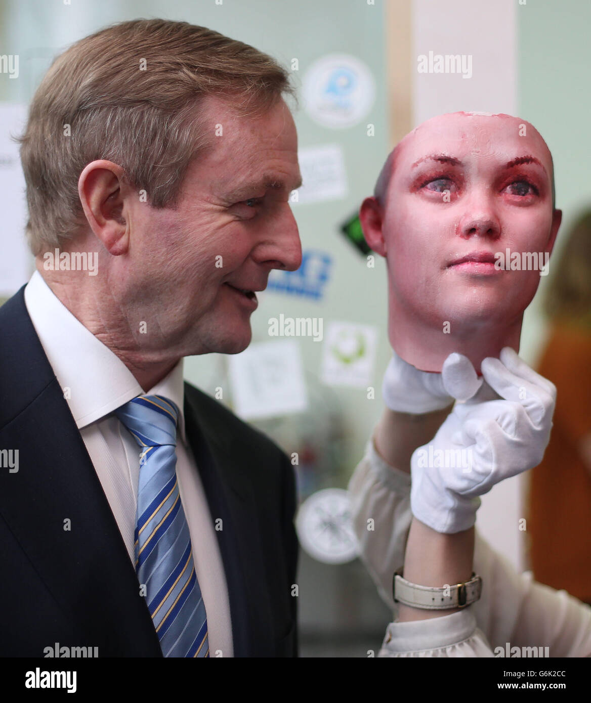 Taoiseach Enda Kenny si pone con una maschera mentre aiuta a lanciare il programma di quattro nuove mostre per il 2014 presso la Science Gallery del Trinity College. La maschera è stata creata utilizzando tracce di DNA umano trovate sui mozziconi di sigaretta che si stagliano per le strade di Dublino, che sono stati portati in un laboratorio ed è stata eseguita un'estrazione di DNA. Certe regioni del DNA sono state amplificate usando una tecnica chiamata reazione a catena PCR-polimerasi. Ciò rende possibile studiare alcune regioni del genoma che tendono a variare da persona a persona, note come polimorfismi di singolo nucleotide (SNP). Foto Stock
