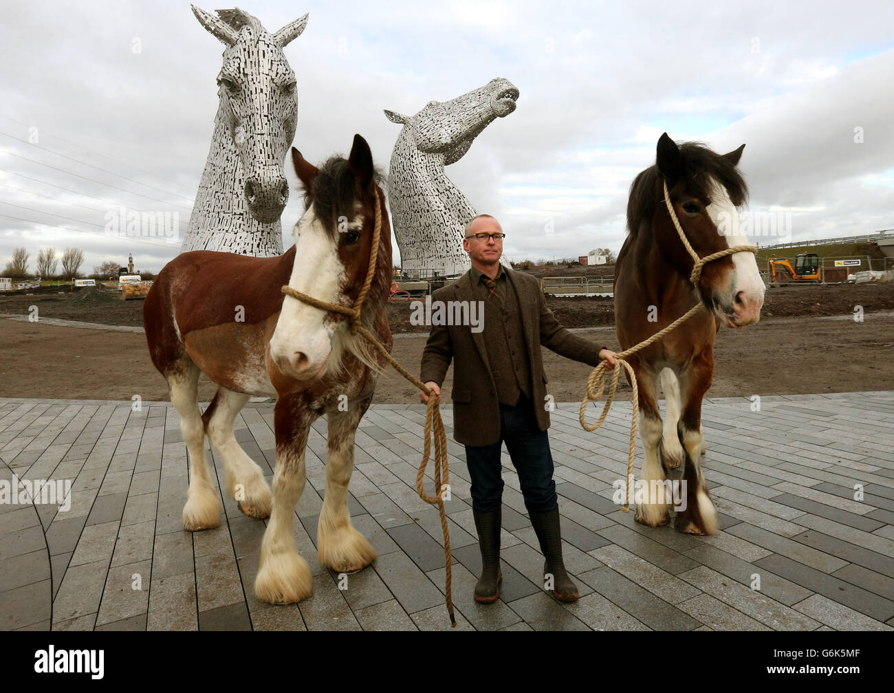 L'artista Andy Scott con Clydesdale Horses Duke (a sinistra) e Baron mentre svela la sua scultura The Kelpies, un'attrazione per visitatori e arte pubblica, che forma una porta d'ingresso al canale Forth e Clyde presso l'Helix, Falkirk, Scozia. Foto Stock