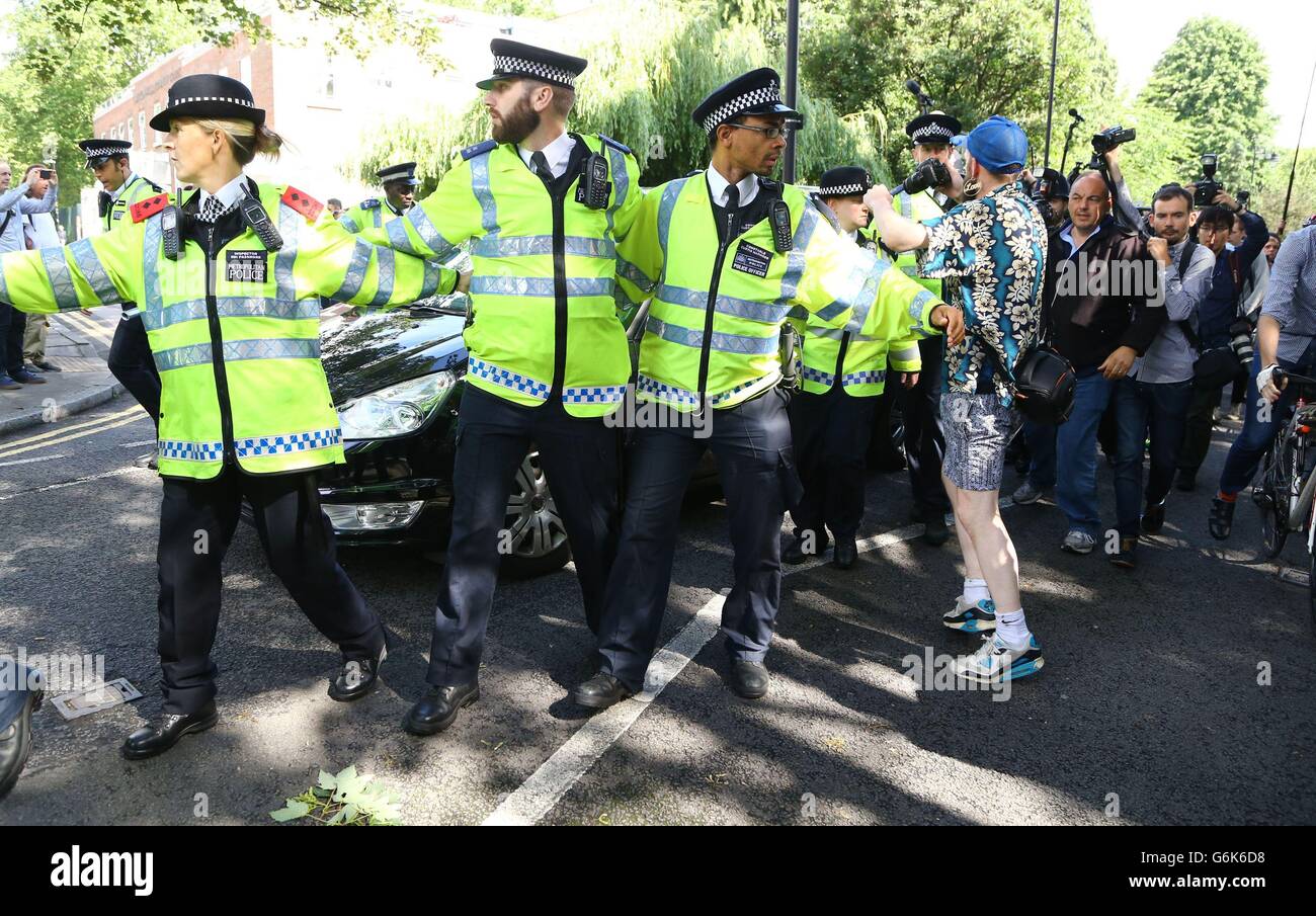 Gli uffici di polizia di bracci di collegamento nella parte anteriore di una macchina portante Boris Johnson dalla sua casa nel nord di Londra, dopo David Cameron ha annunciato che farà uscire come Primo Ministro da ottobre a seguito di una umiliante sconfitta nel referendum che si è conclusa con un voto per la Gran Bretagna a lasciare l'Unione europea. Foto Stock