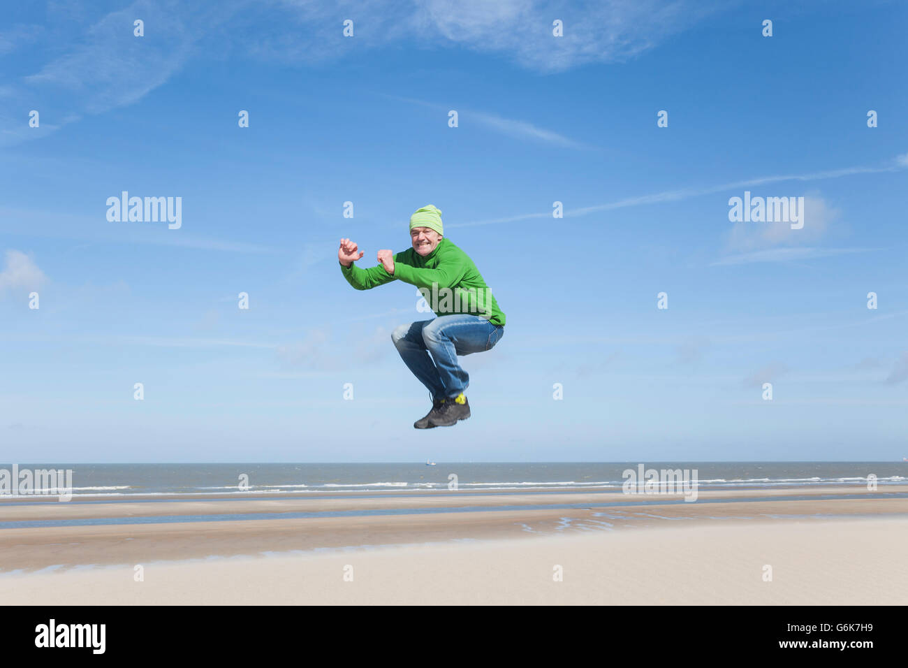 Entusiastico uomo maturo salto sulla spiaggia Foto Stock