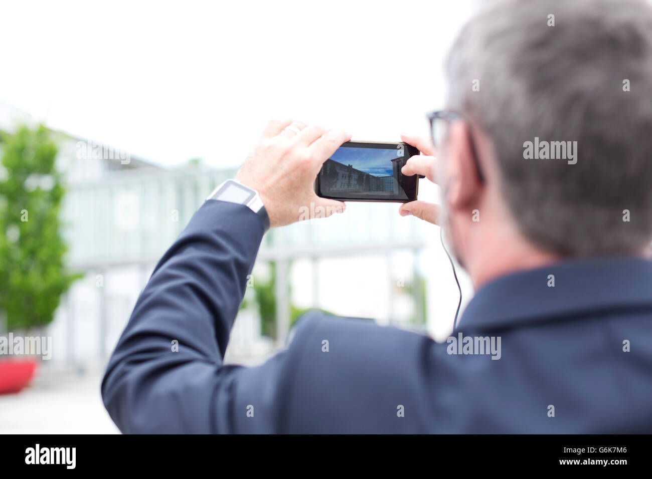 Imprenditore all'aperto prendendo un telefono cellulare foto Foto Stock