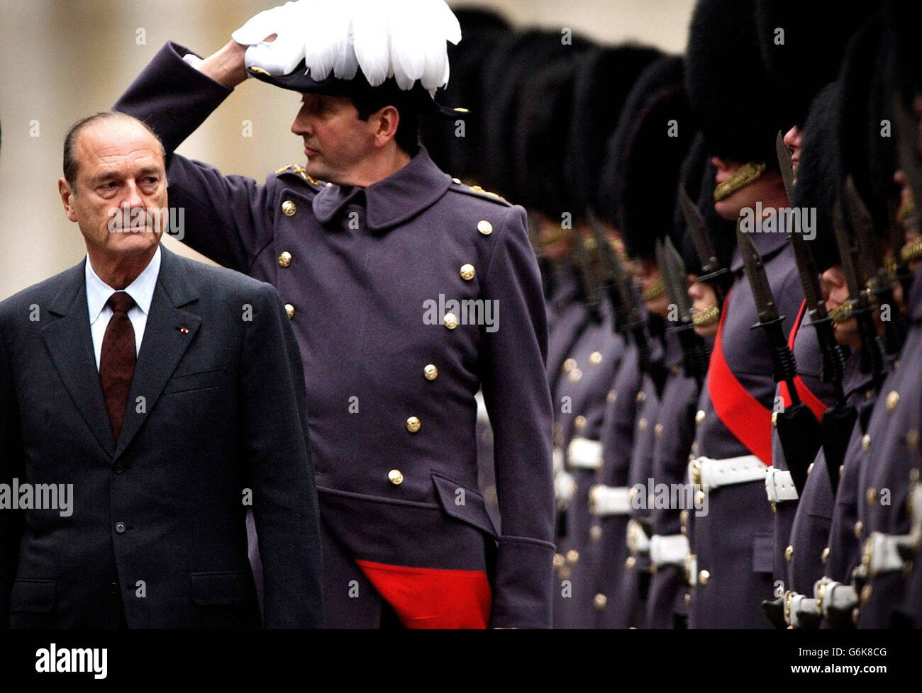 Il presidente francese Jacques Chirac durante un'ispezione della Guardia d'onore da parte delle Guardie di Grenadier presso il Ministero degli Esteri, nel centro di Londra. Il leader francese si recava a Downing Street per colloqui con il primo ministro britannico Tony Blair, pochi giorni dopo la conclusione della visita di Stato del presidente degli Stati Uniti George Bush, Ciò riflette l'importanza che Blair attribuisce alla guarigione della spaccatura tra Londra e Parigi che si è sviluppata sul conflitto iracheno. Foto Stock