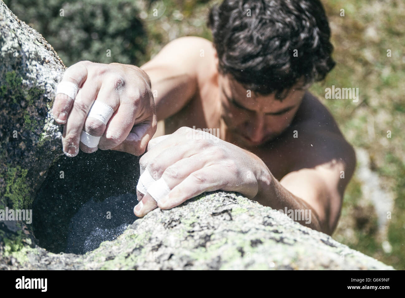 Le mani di un alpinista con cerotto e chalk durante una arrampicata boulder Foto Stock