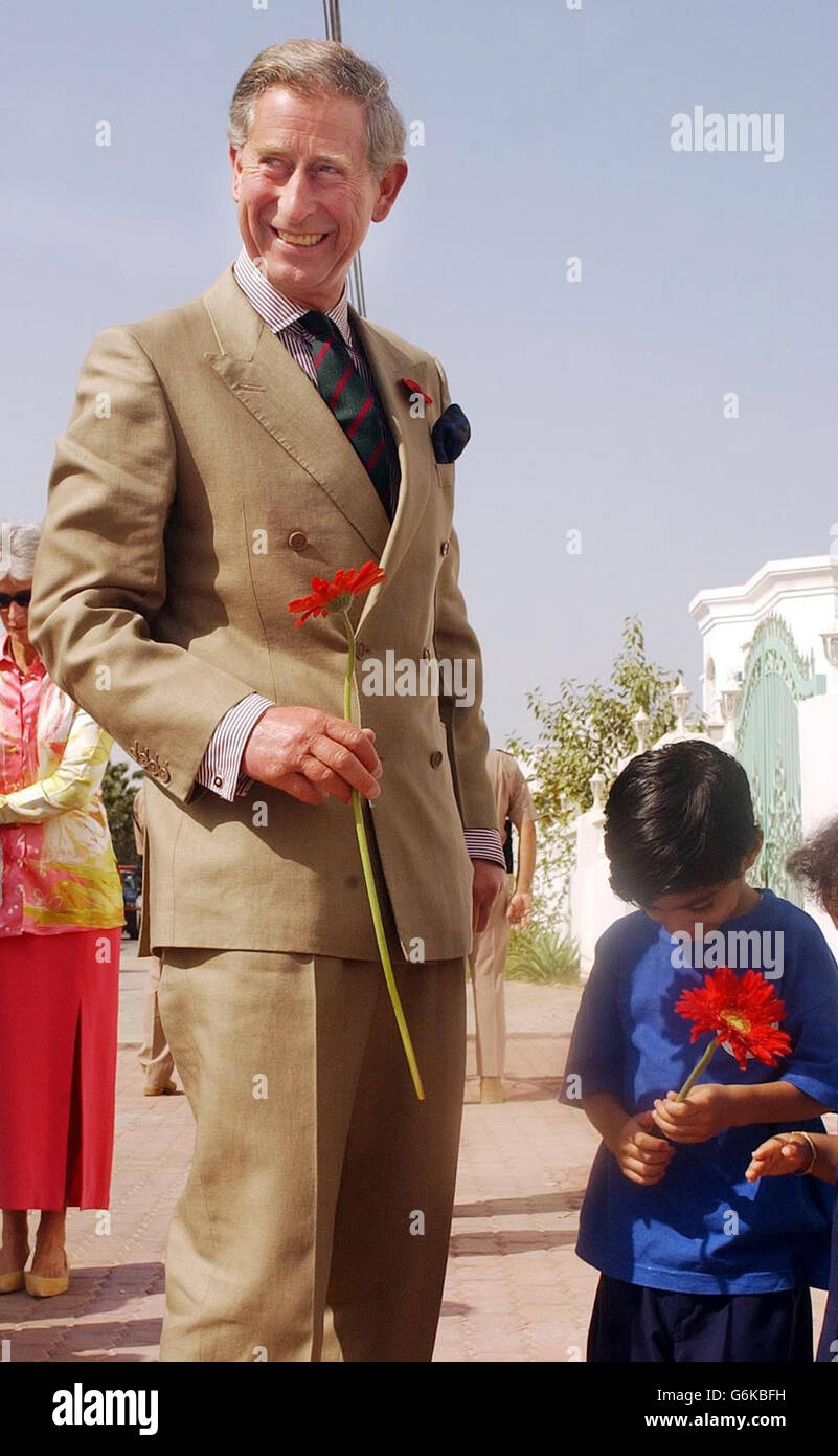 Il Principe del Galles accetta un fiore di un giovane Omani quando arriva all'Associazione di intervento precoce per bambini con esigenze speciali. Questo pomeriggio, il Principe visiterà la Grande Moschea del Sultano Qaboos a Mascate, il principale punto di riferimento del culto nel Sultanato. Foto Stock